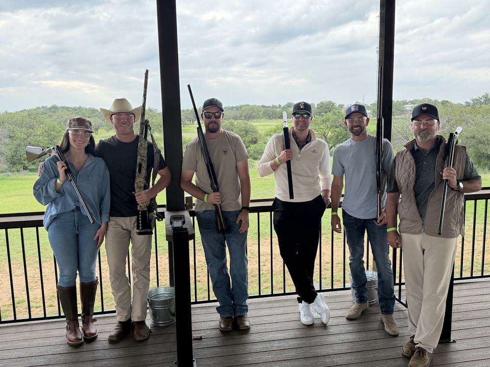 Horseshoe Bay's golf professionals and Director of Retail Operations holding shotguns on a covered shooting deck