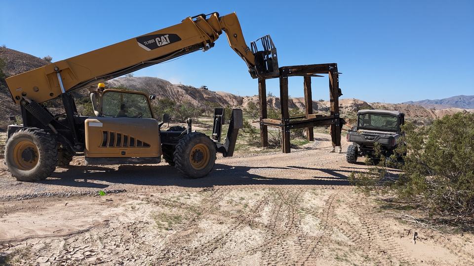 Setting a timber station frame with a telehandler.
