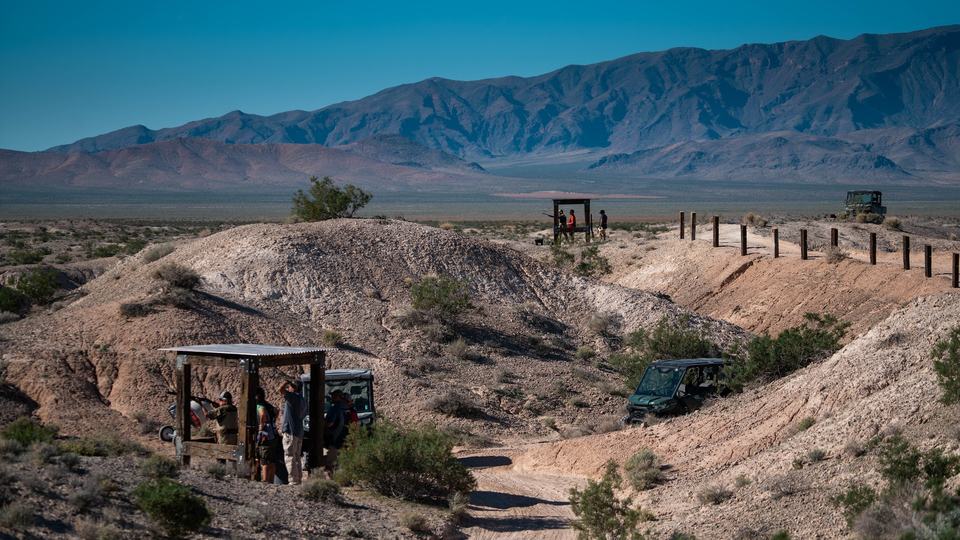 A finished station on the ridge, mountains behind.