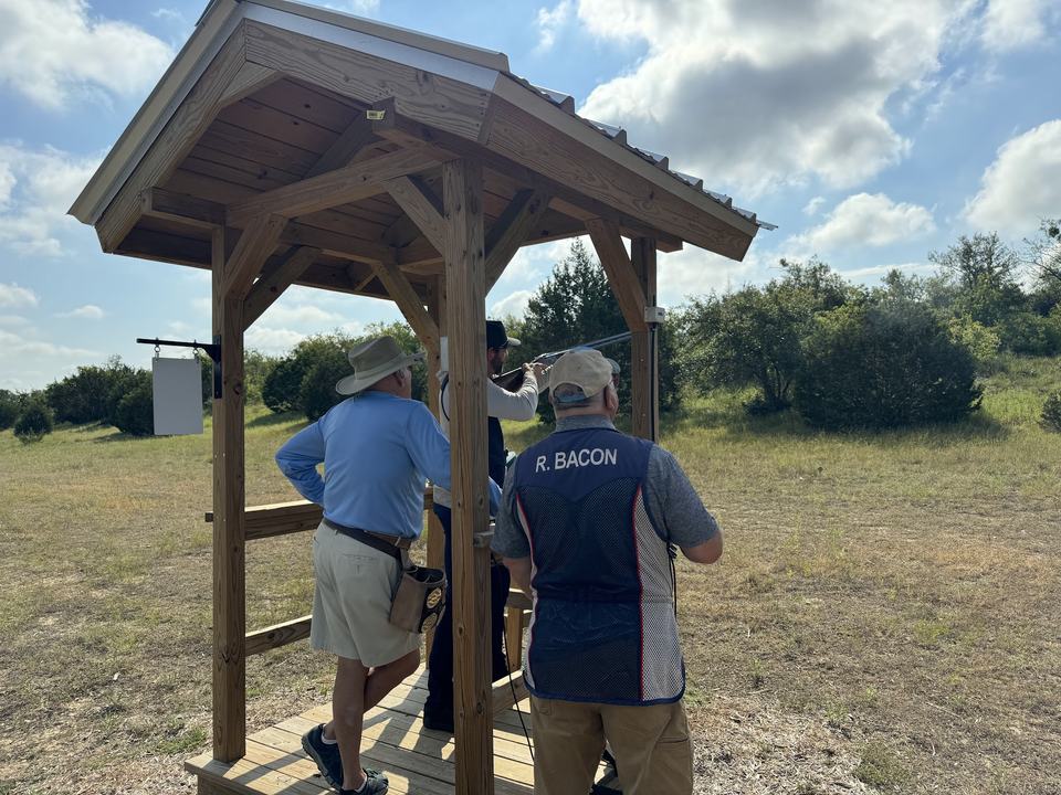 Shooters and a coach at the stand.