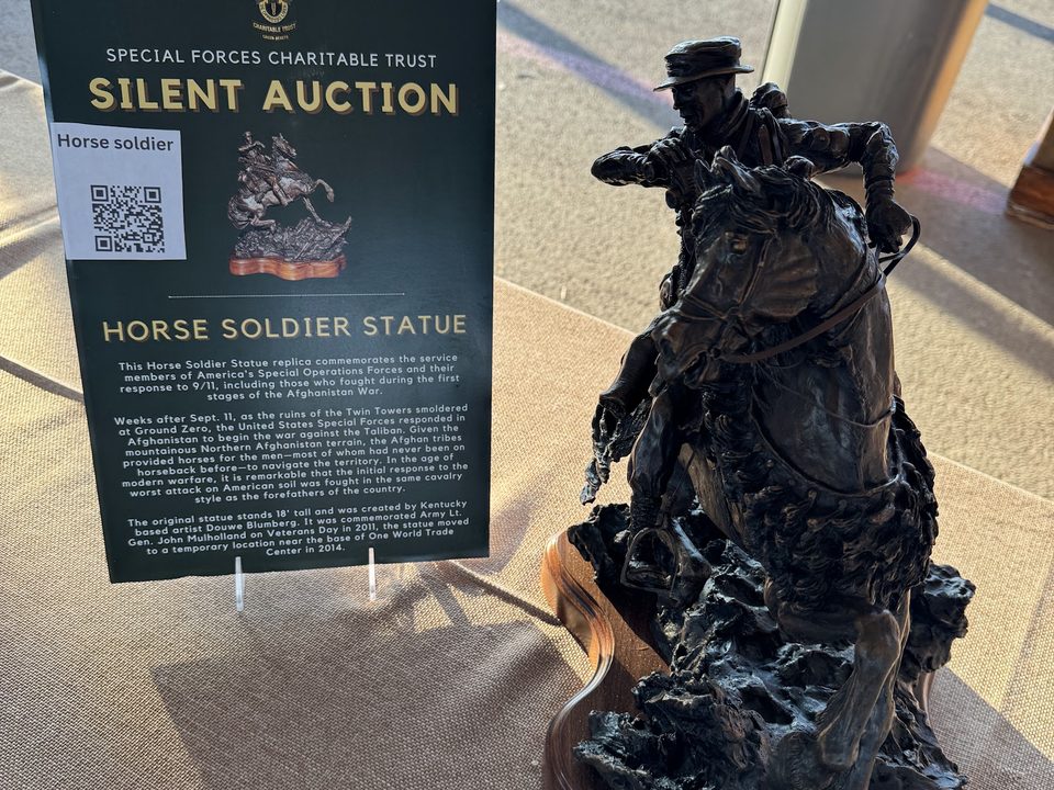 A Horse Soldier statue beside a Special Forces Charitable Trust silent auction sign